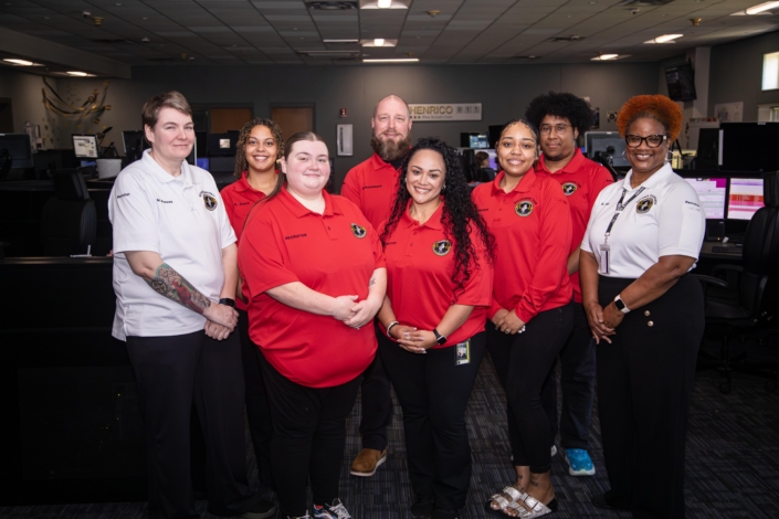 Group of Henrico 911 dispatchers standing in a room smiling.