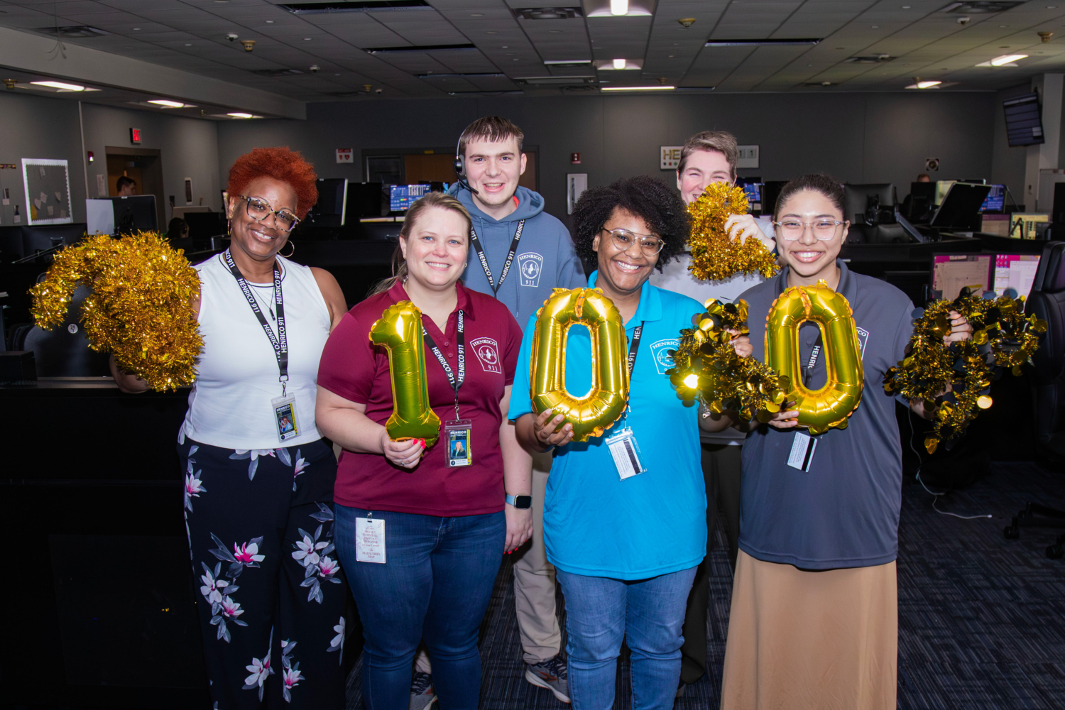 100th BPA recruiting group (3) Group of 911 dispatchers holding "100" shaped balloons and garland.